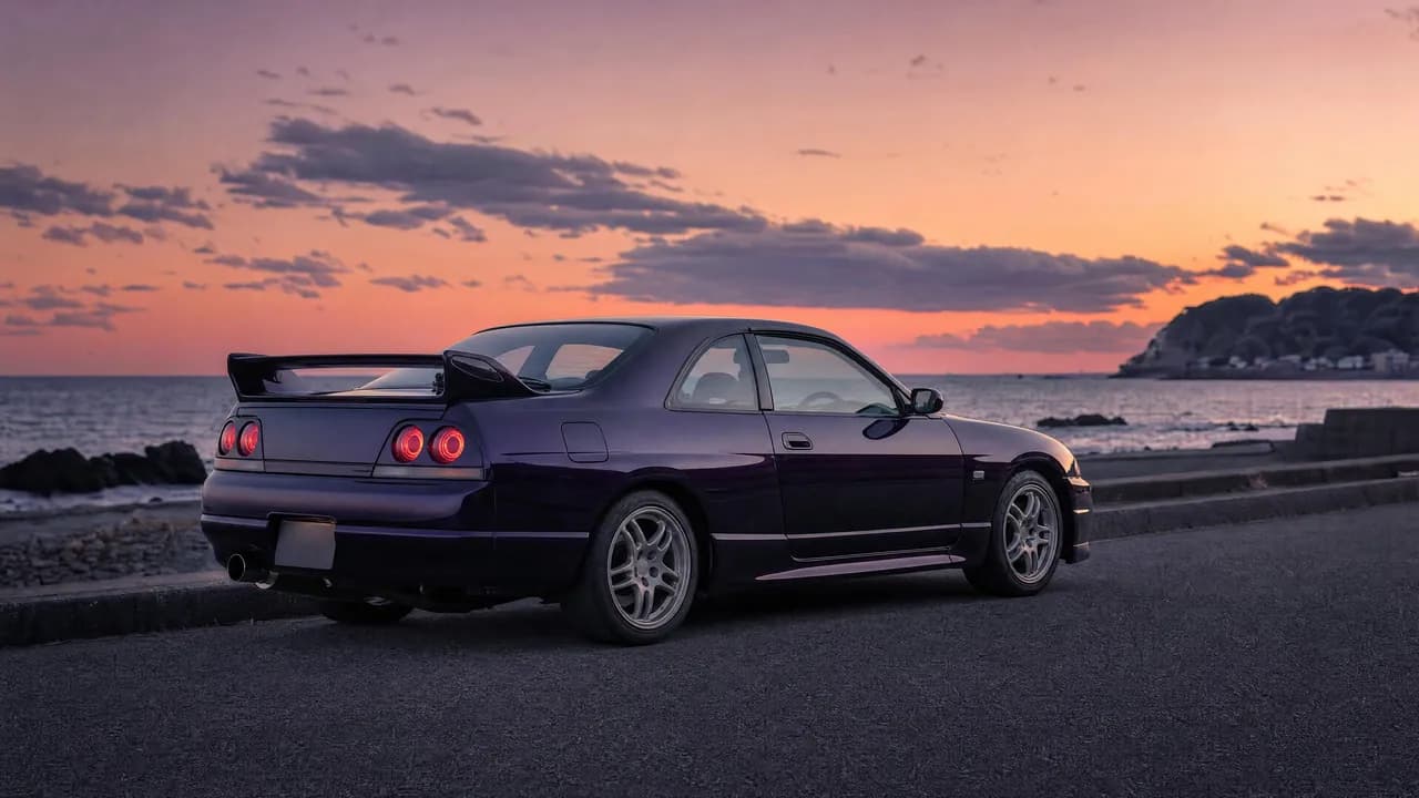 Midnight purple R33 Skyline GT-R on a coastal road at dusk