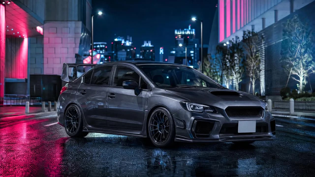 Grey Subaru WRX STI in a neon city at night