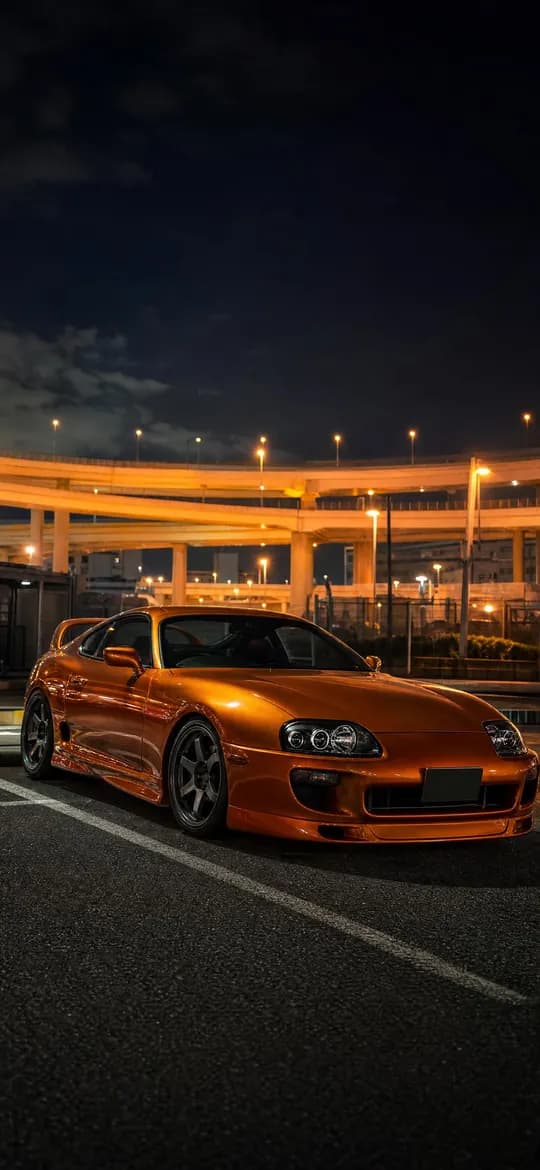 Orange Toyota Supra MK4 at Daikoku parking area at night, phone wallpaper