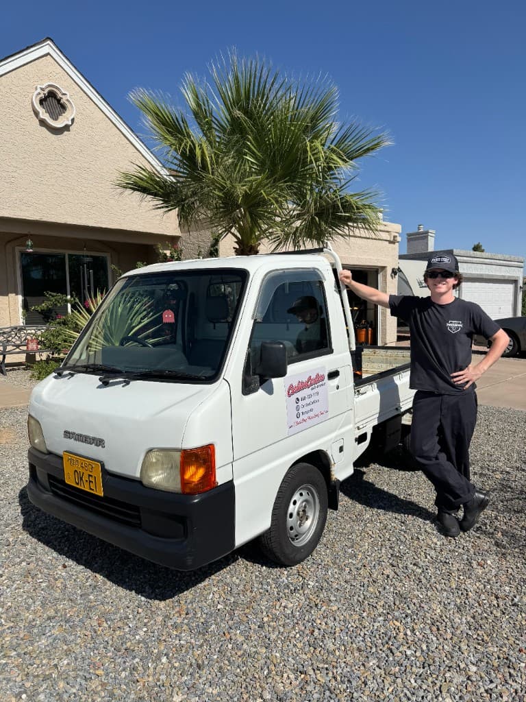 Carlos standing next to his white Subaru Sambar kei truck used for his mobile auto mechanic business